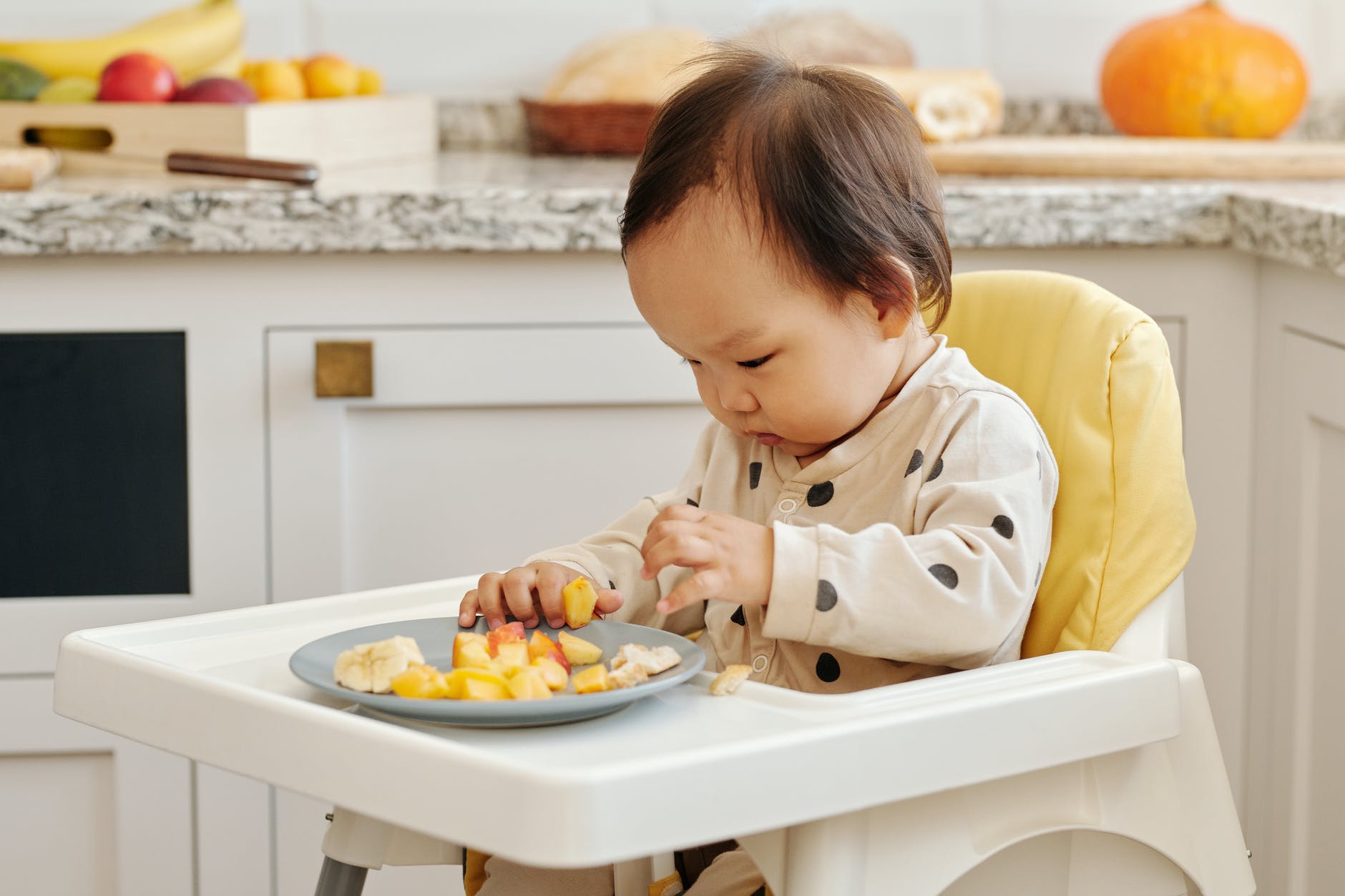 boy in white dress shirt eating food on white table